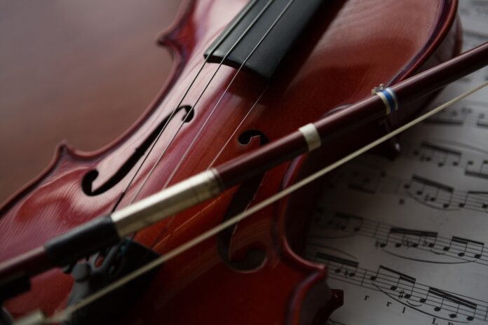 Close up of brown violin with sheet music